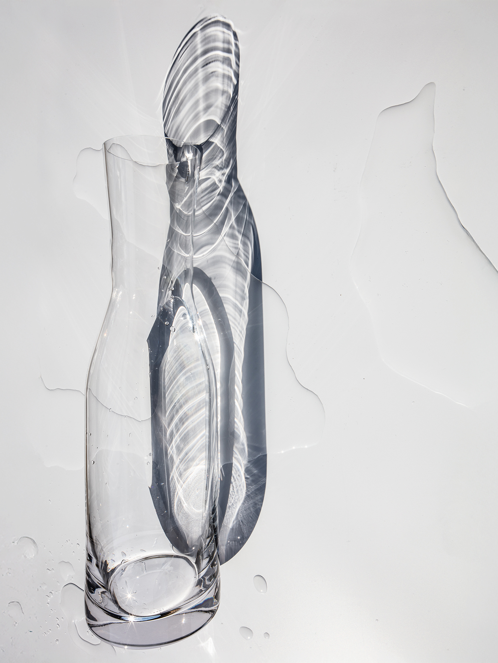 Glass water carafe with light reflections and water shadows