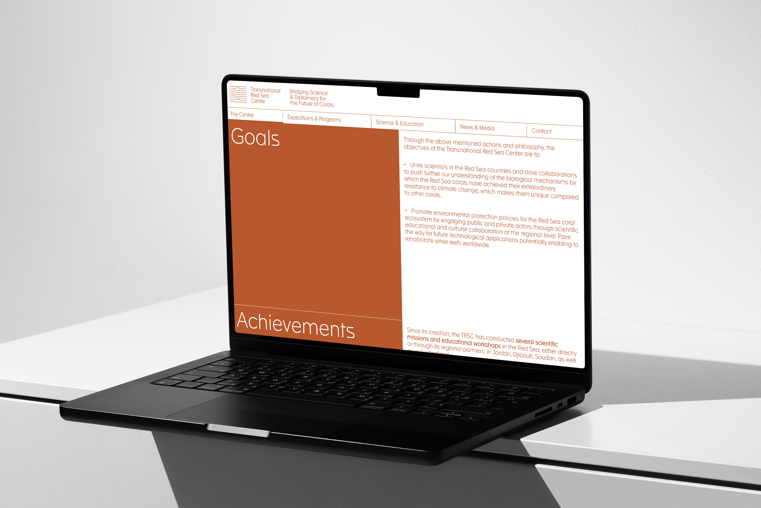 laptop displaying scientific website interface with red layout