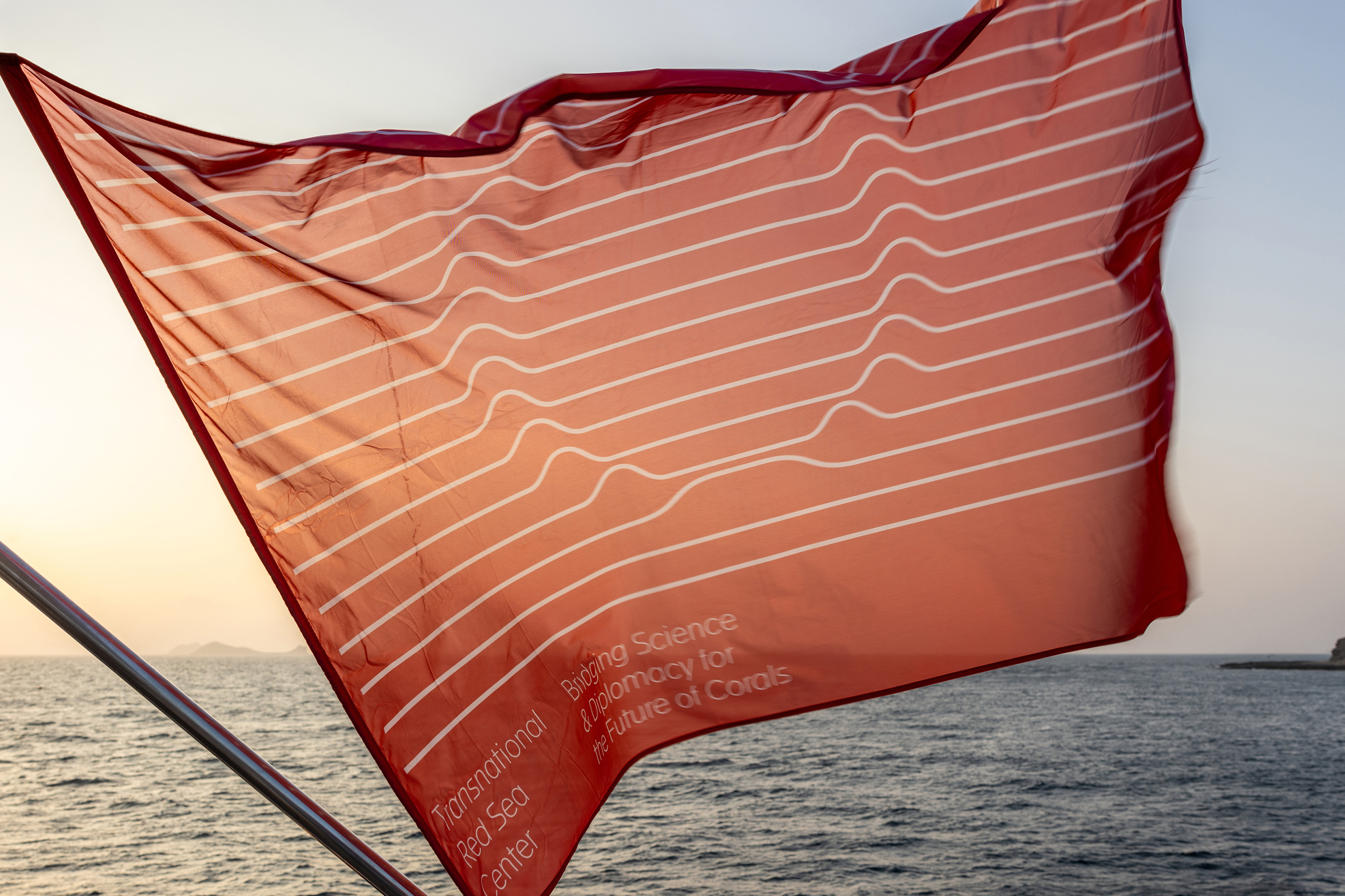 red flag with white line pattern over sea
