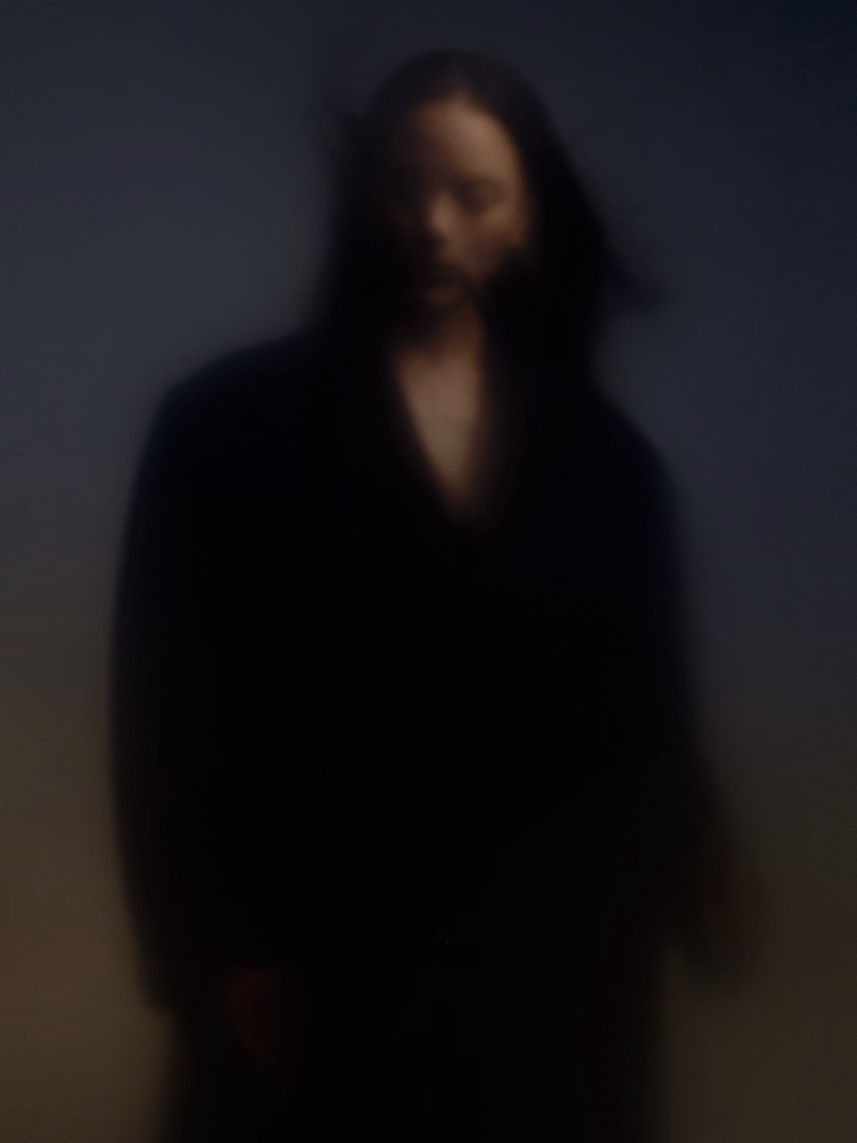 blurred portrait of woman in dark clothing with soft gradient light