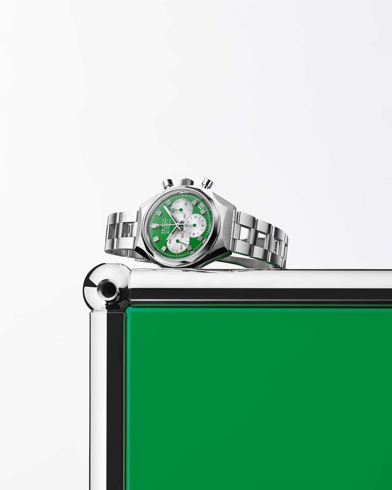 Watch with green dial resting on modular metal structure with colored panel