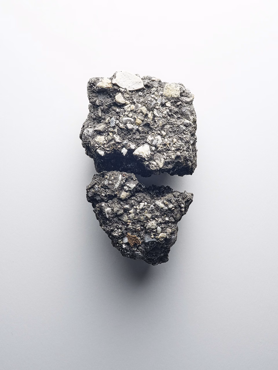 Still life of broken concrete fragment with embedded mineral particles