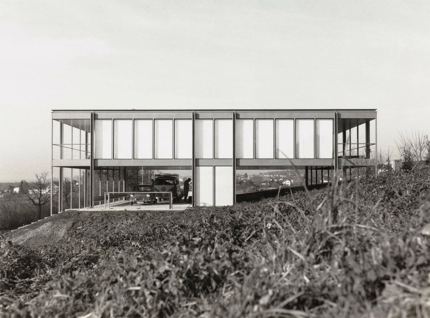 Modernist glass and steel house by Fritz Haller set in natural landscape