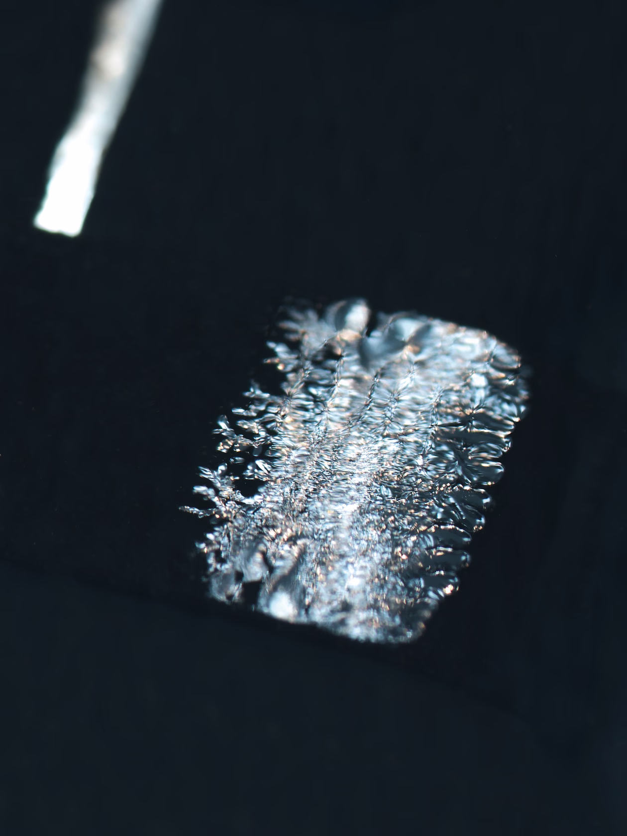 Close-up of photovoltaic surface with linear cell pattern and reflections