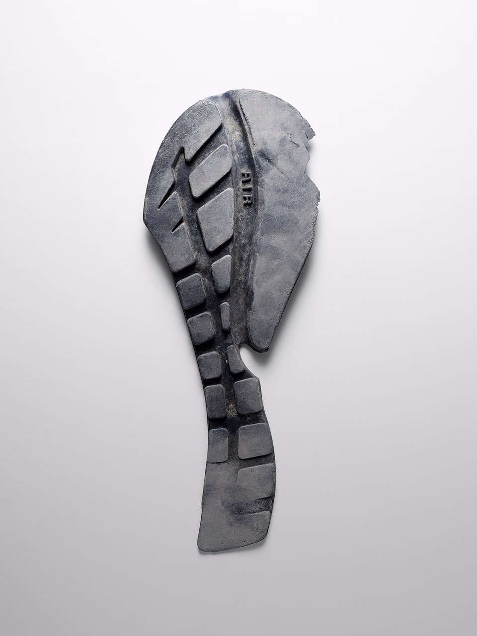 Still life of worn shoe sole fragment with geometric tread pattern